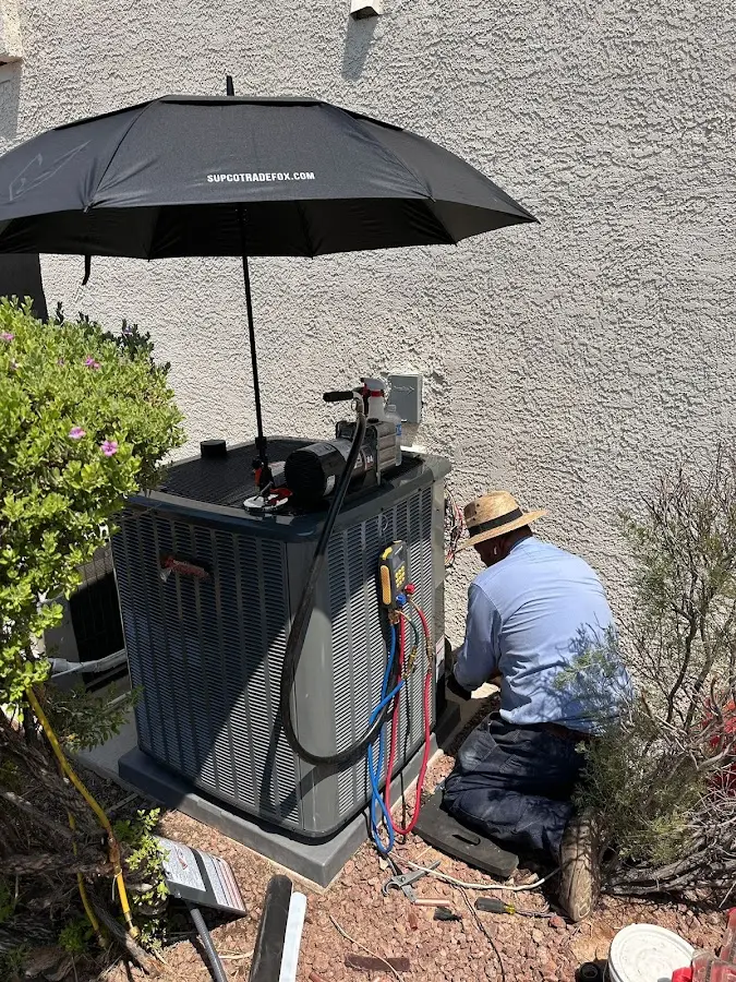 HVAC technician performing outdoor AC maintenance in Ferguson