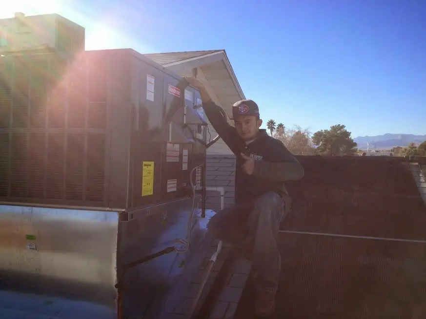 HVAC technician performing AC Tune-Up on a rooftop unit in Ferguson